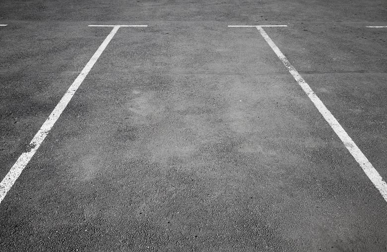 Empty parking place with white marking lines on asphalt